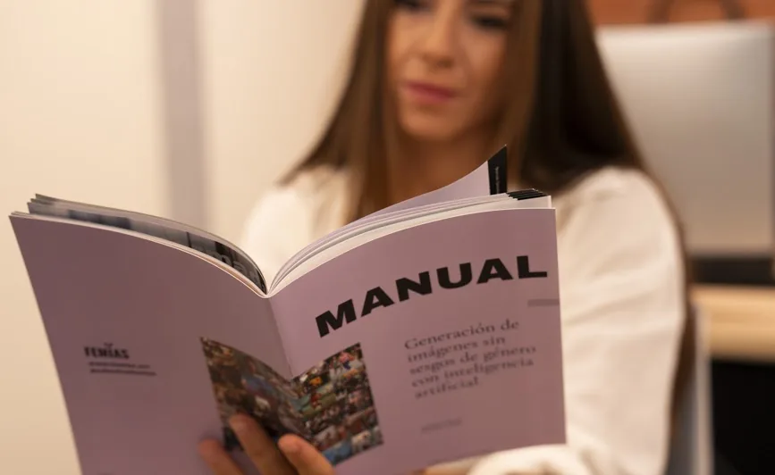Una lectora hojea el manual «Generación de imágenes sin sesgos de género con inteligencia artificial»