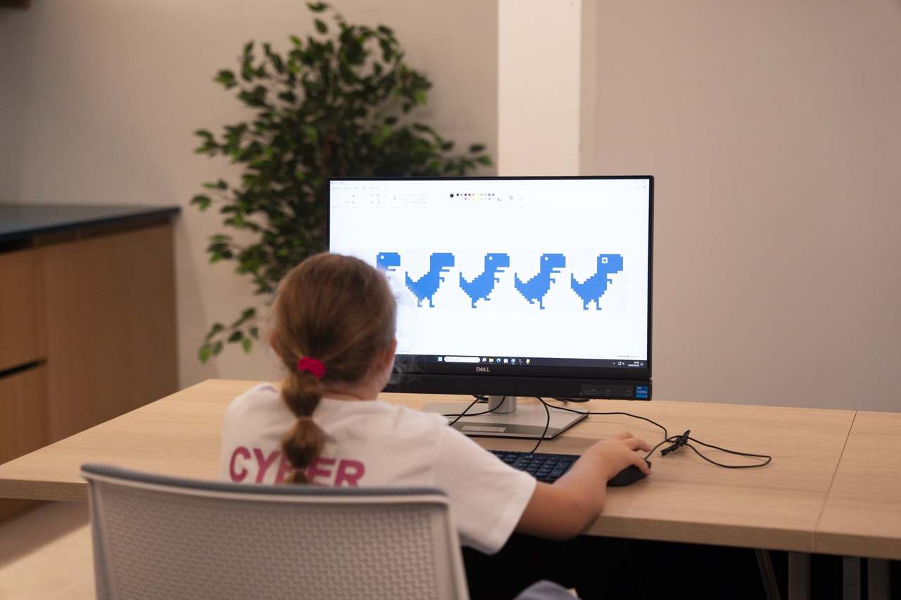 Niñas personalizando el juego del dinosaurio de Google en el taller de minihackers
