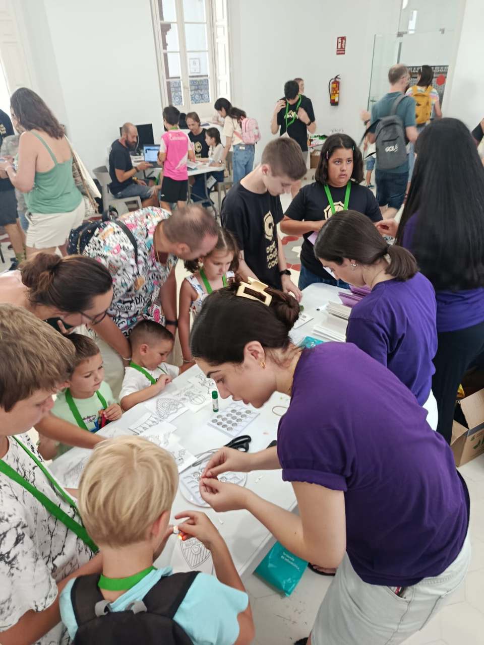 Familias en el stand de Yes We Tech con el manual Damos con la tecla